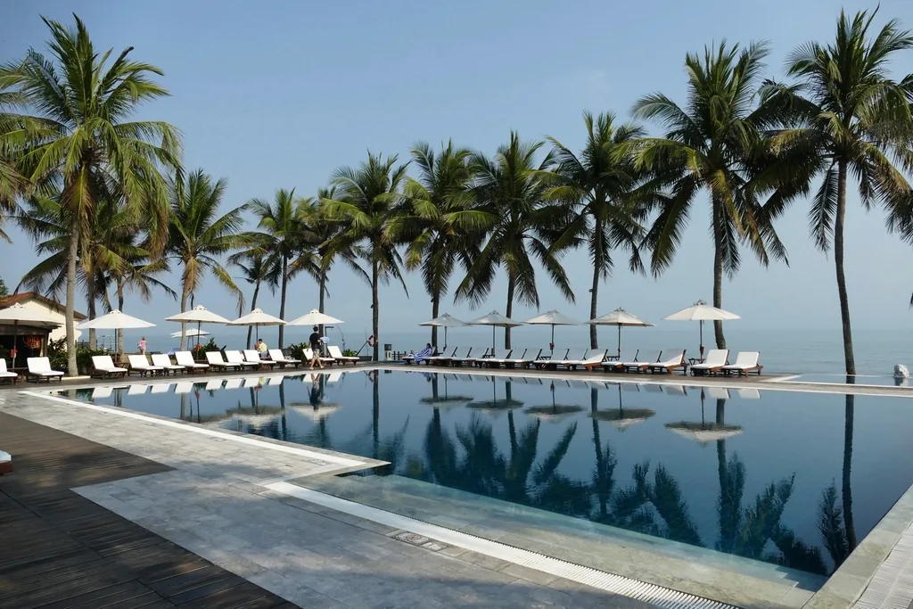 A palm-lined pool at dawn with mirror-still reflections